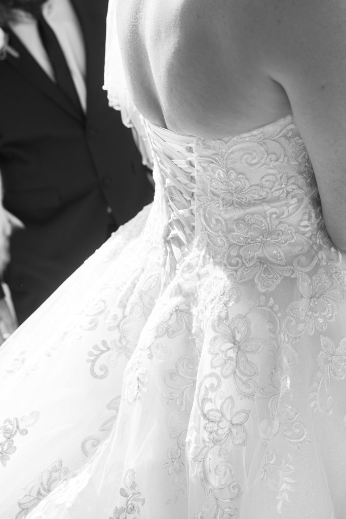 Black and white close-up of the lace-up back of the bride's dress