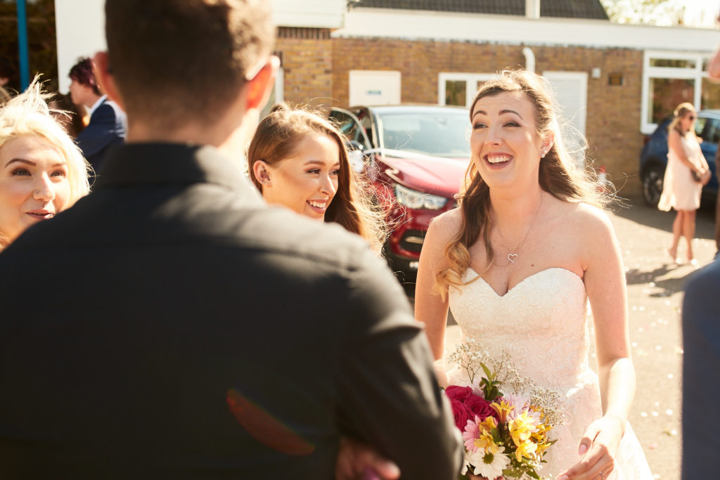 Bride laughing with guests outside the church