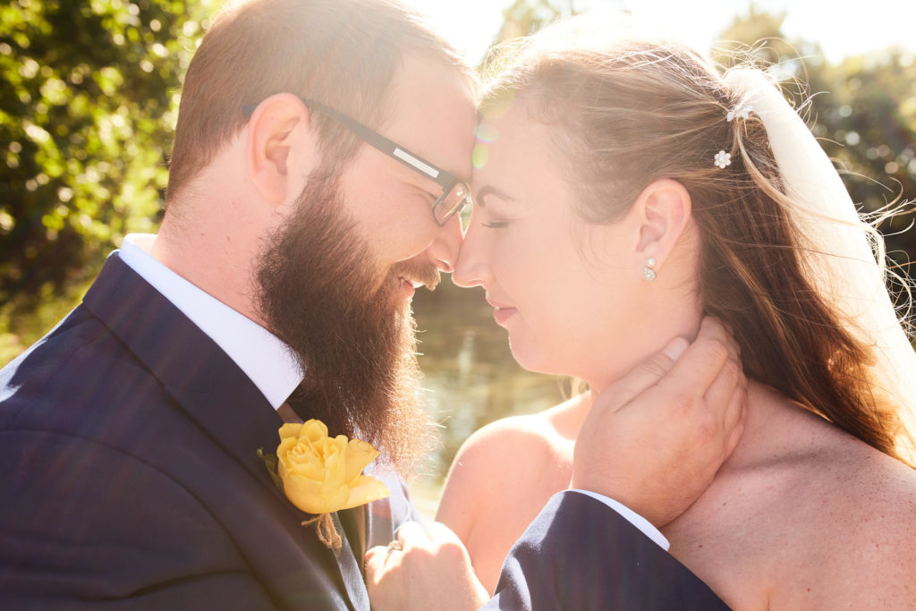 Bride and groom forehead to forehead in golden backlight at Villiers Barn