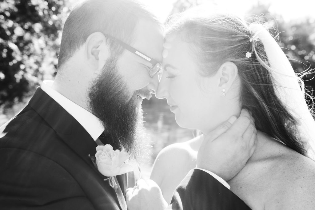 Black and white photo of the bride and groom forehead to forehead