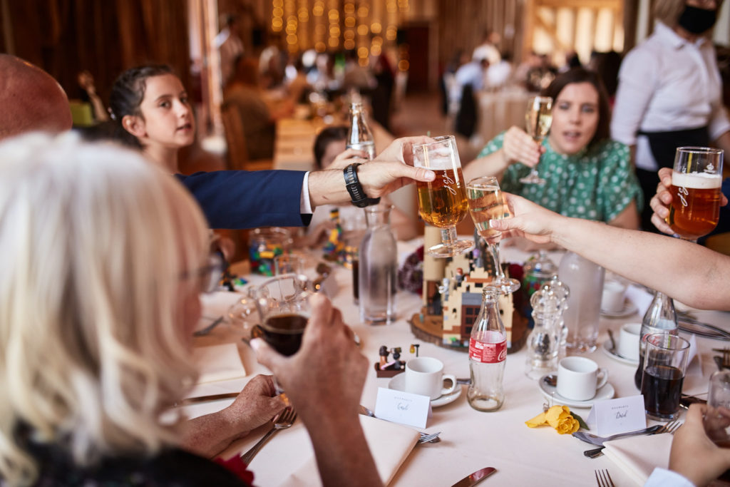 Wedding guests clinking glasses across the table