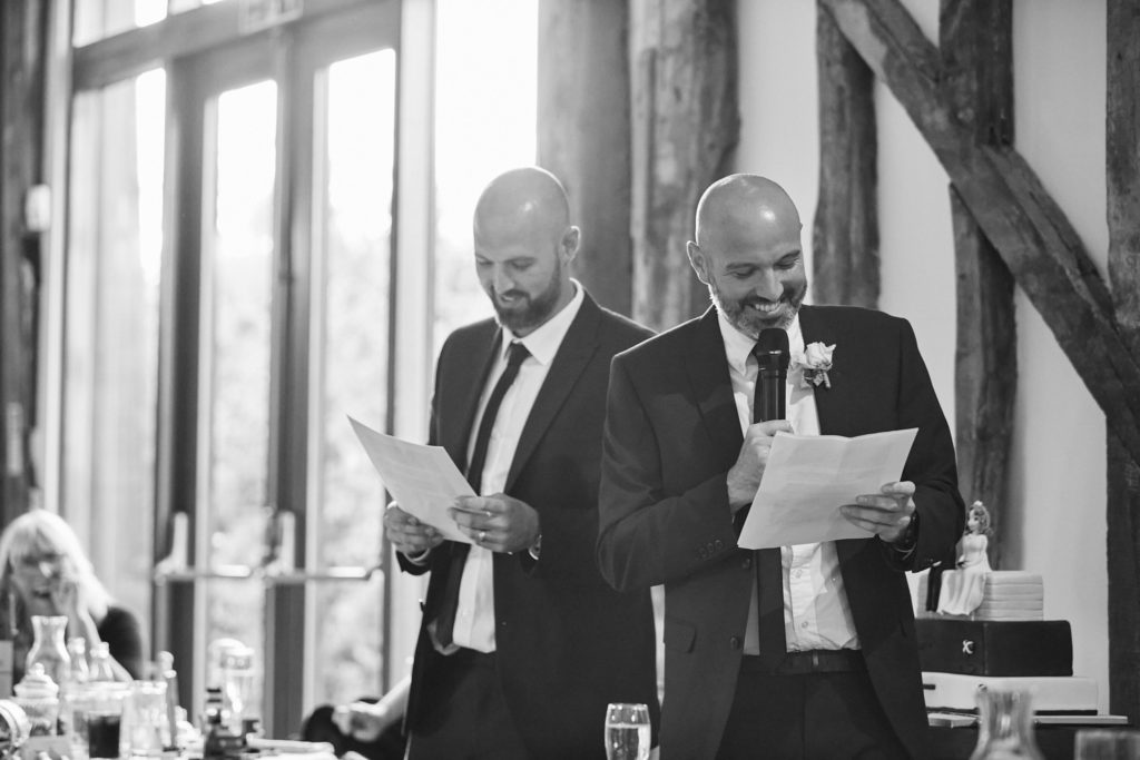 Black and white photo of two men reading a speech together