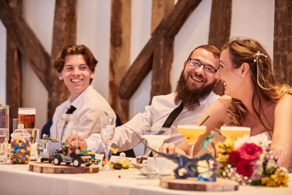 Bride and groom laughing at the top table with the best man