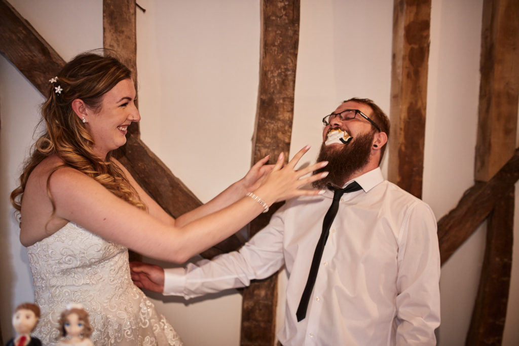 Bride cupping the laughing groom's face in her hands