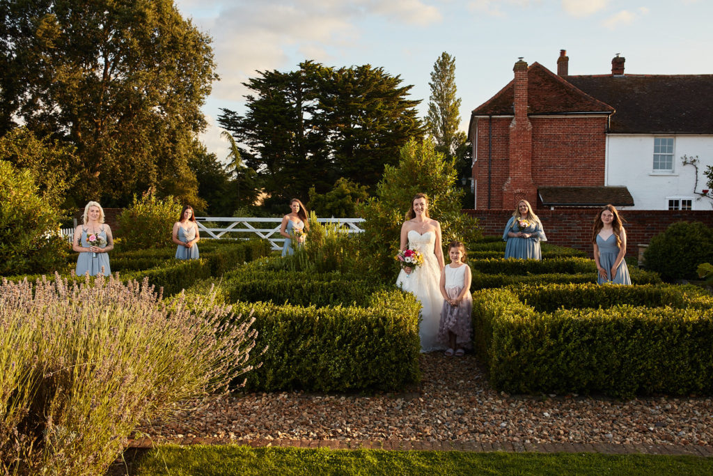 Bride walking through the formal hedged garden at Villiers Barn