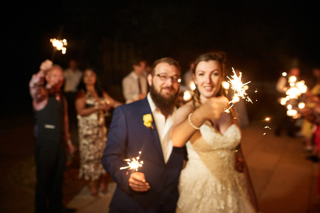Bride and groom waving sparklers with their guests outside Villiers Barn