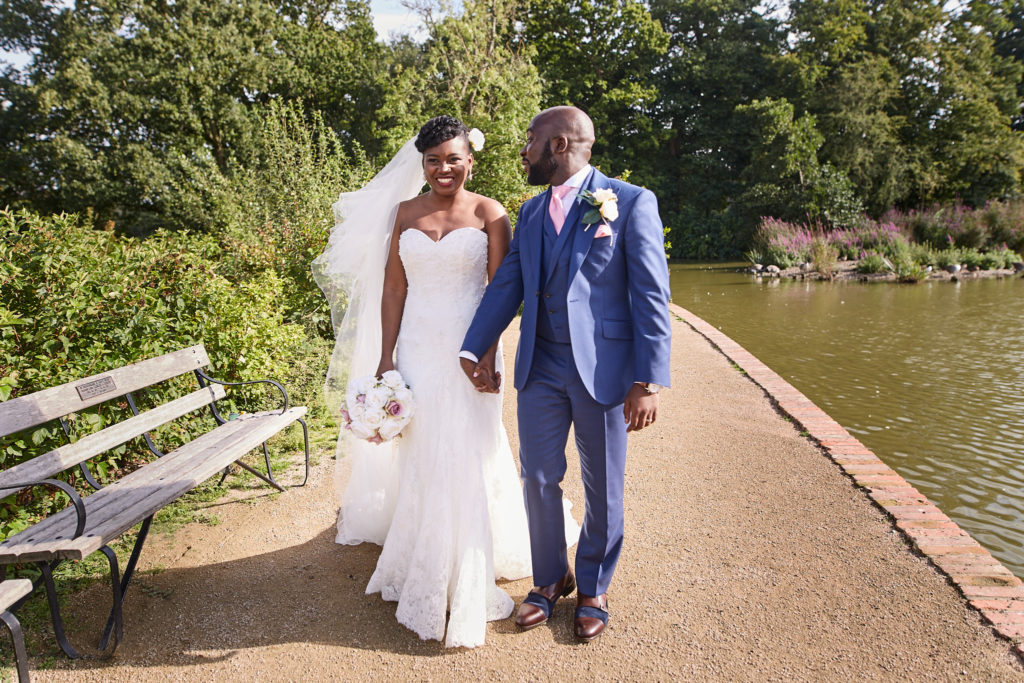 Bride and groom walking beside the lake at Forty Hall