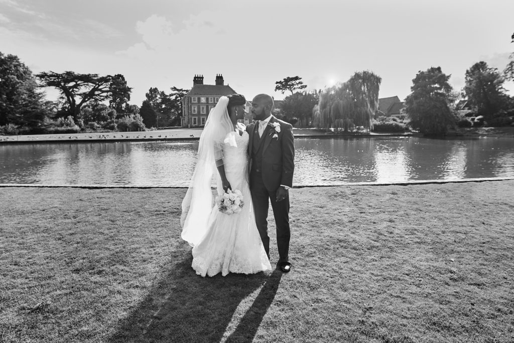 Black and white photo of the bride and groom beside the lake at Forty Hall