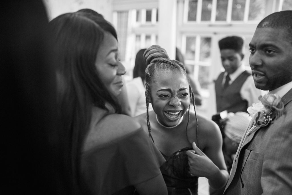 Black and white photo of guests laughing together at the reception