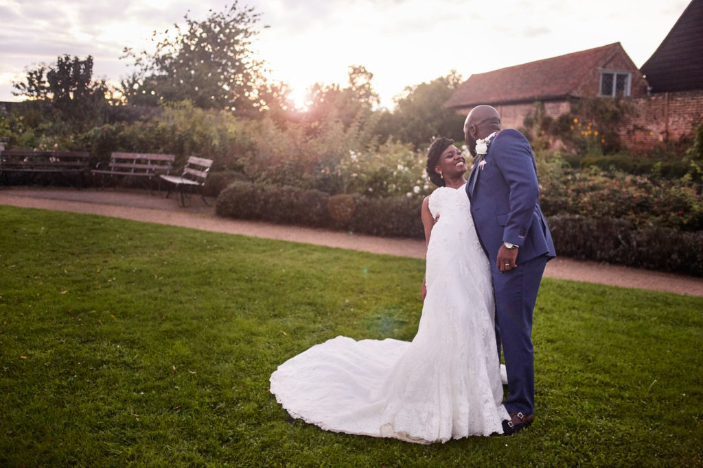 Bride and groom standing on the lawn at sunset at Forty Hall