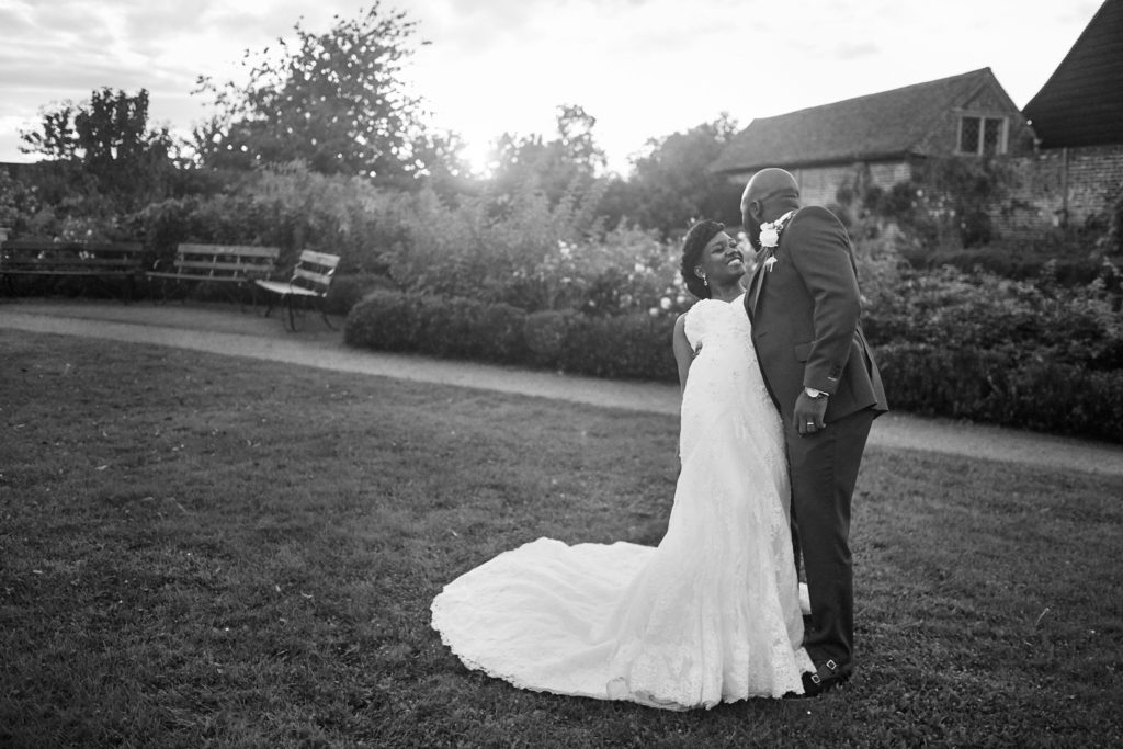 Black and white photo of the bride and groom kissing on the lawn at Forty Hall