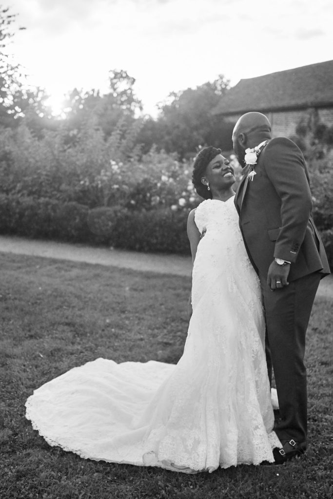 Black and white photo of the bride laughing with the groom on the lawn at Forty Hall