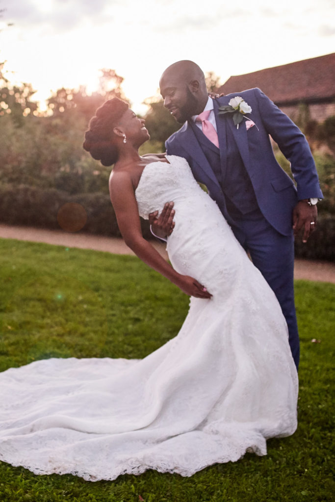 Groom dipping the bride for a kiss at sunset in the gardens of Forty Hall