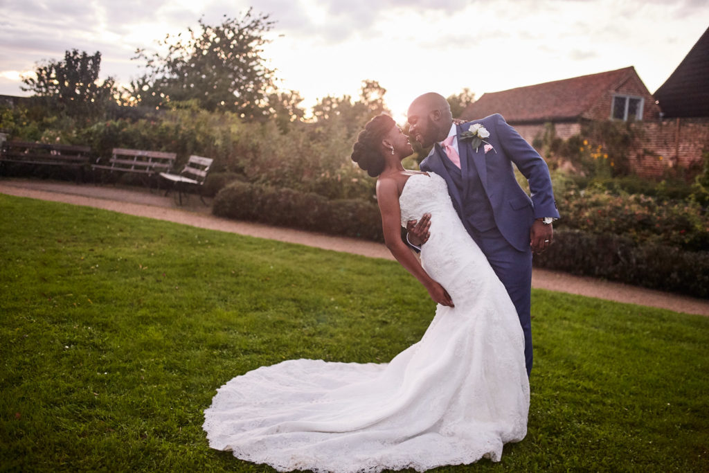 Groom leaning the bride back on the lawn at Forty Hall in evening light