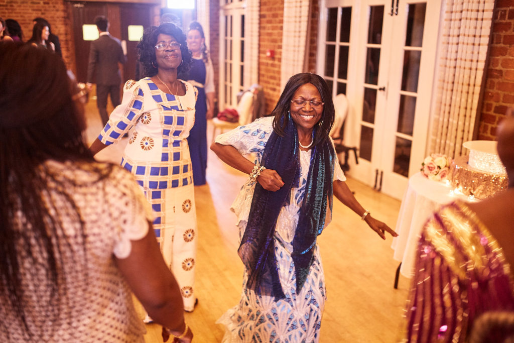 Wedding guests dancing in colourful print outfits