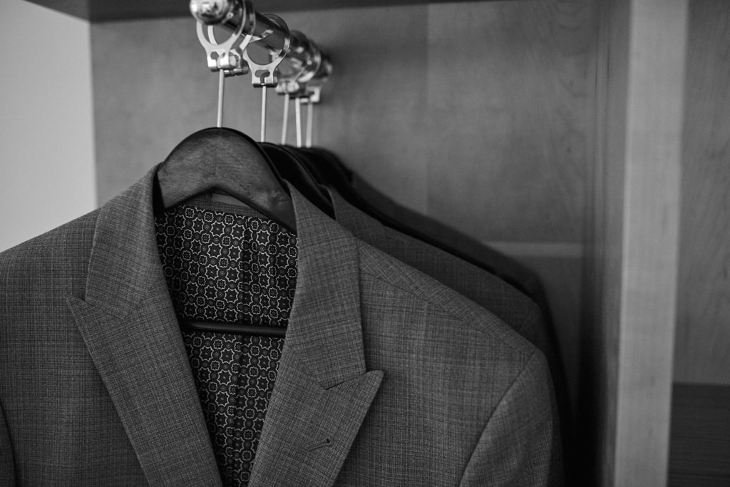 Black and white photo of a suit jacket hanging in a wardrobe