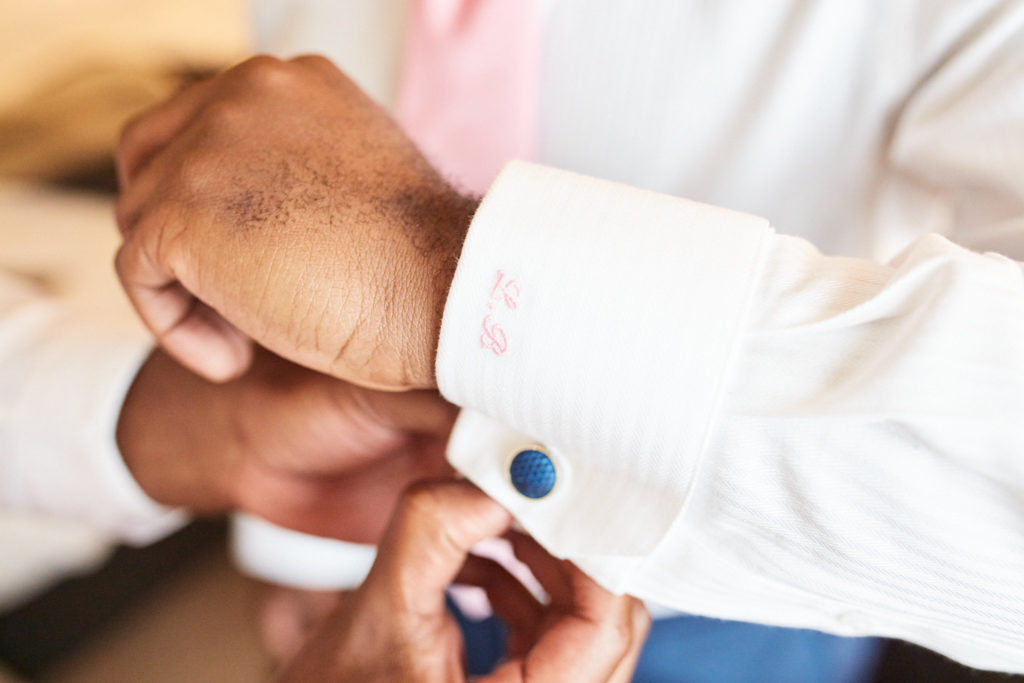 Close-up of the groom fastening his cufflink
