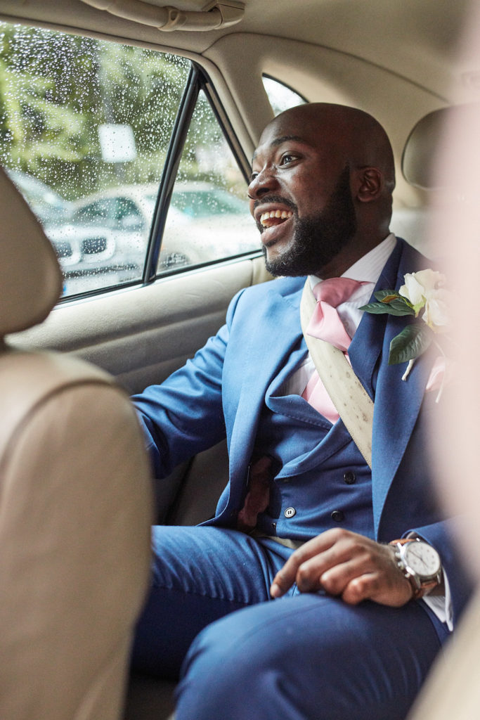 Groom laughing in the back of the wedding car