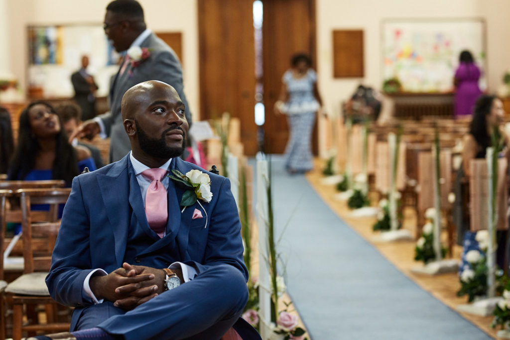 Groom sitting at the front of the church before the ceremony