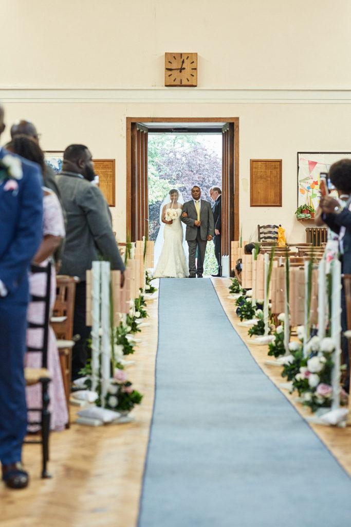 Bride entering the church at the far end of the aisle