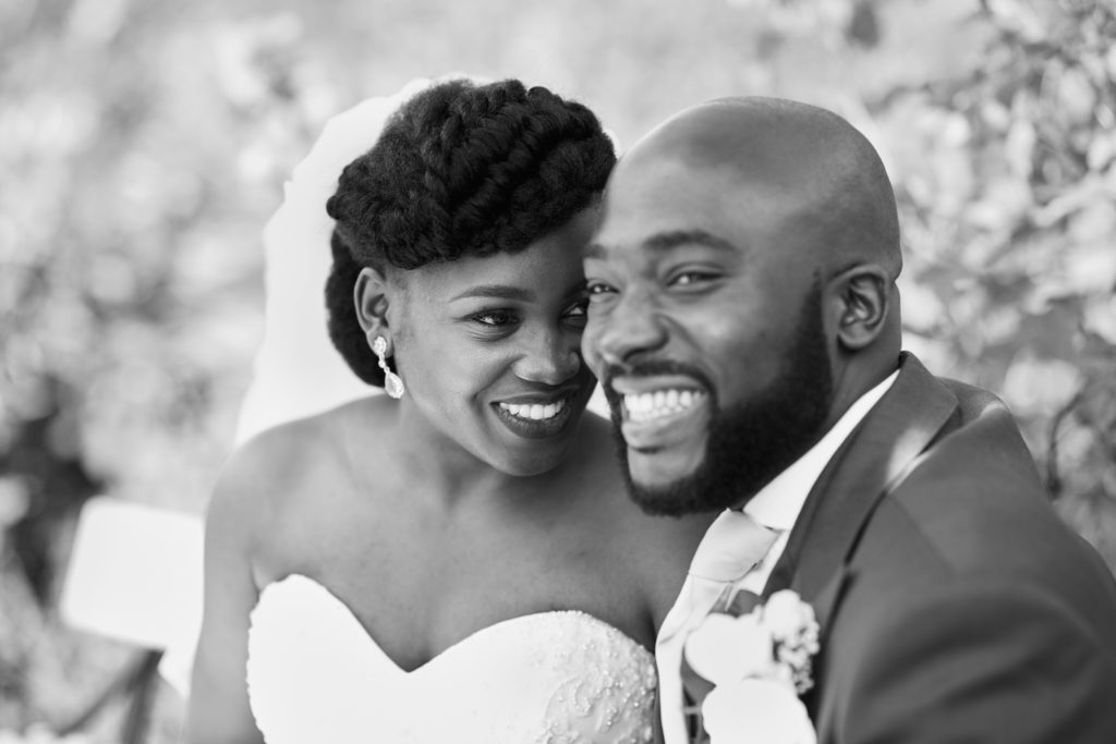 Black and white close-up of the bride and groom laughing cheek to cheek