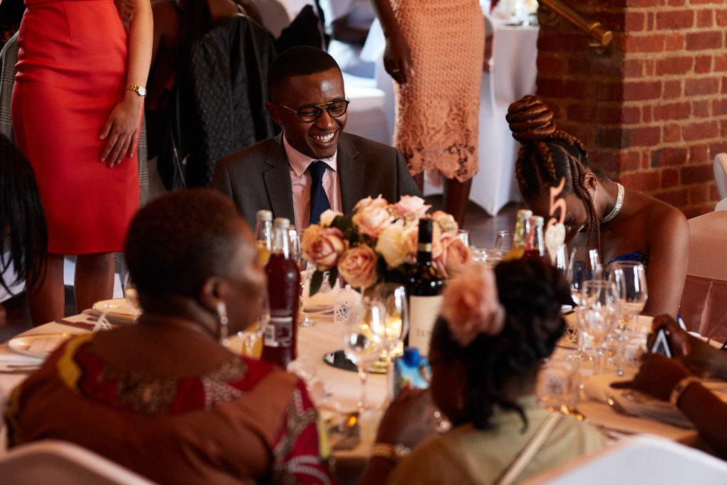 Wedding guests laughing at their table during the wedding breakfast
