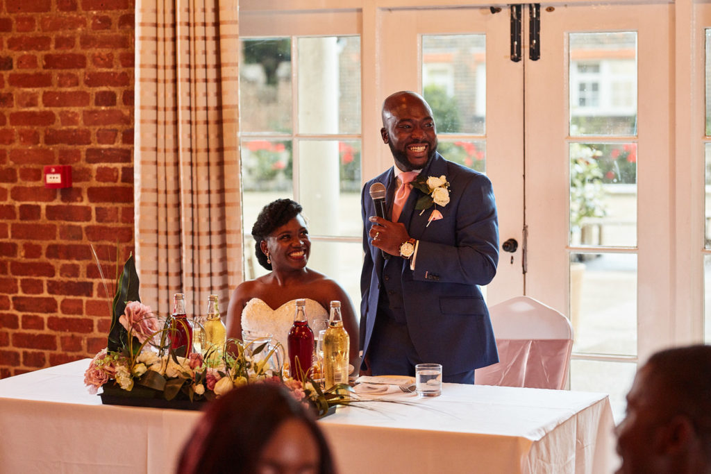 Groom giving his speech as the bride listens