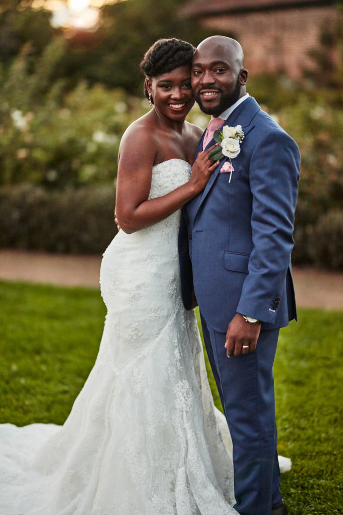 Bride and groom smiling together on the lawn at Forty Hall in evening light