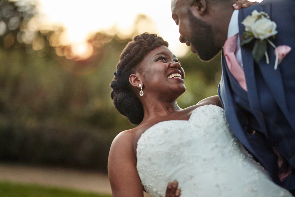 Bride laughing up at the groom at sunset at Forty Hall