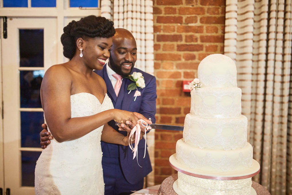Bride and groom cutting their four-tier wedding cake