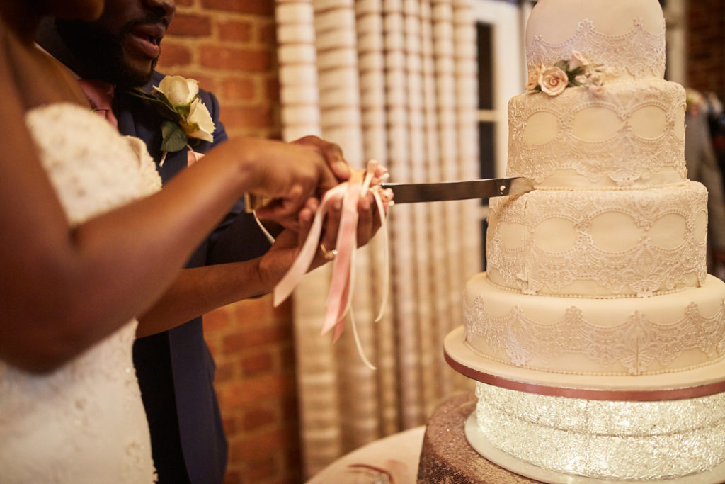 Close-up of the bride and groom cutting the wedding cake