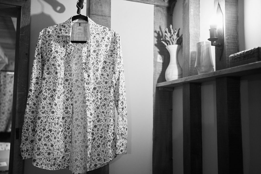 Black and white photo of the groom's floral shirt on a hanger