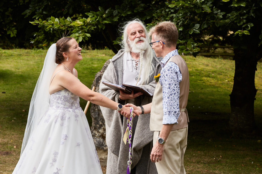 Bride and groom's handfasting ceremony on the lawn with a robed celebrant