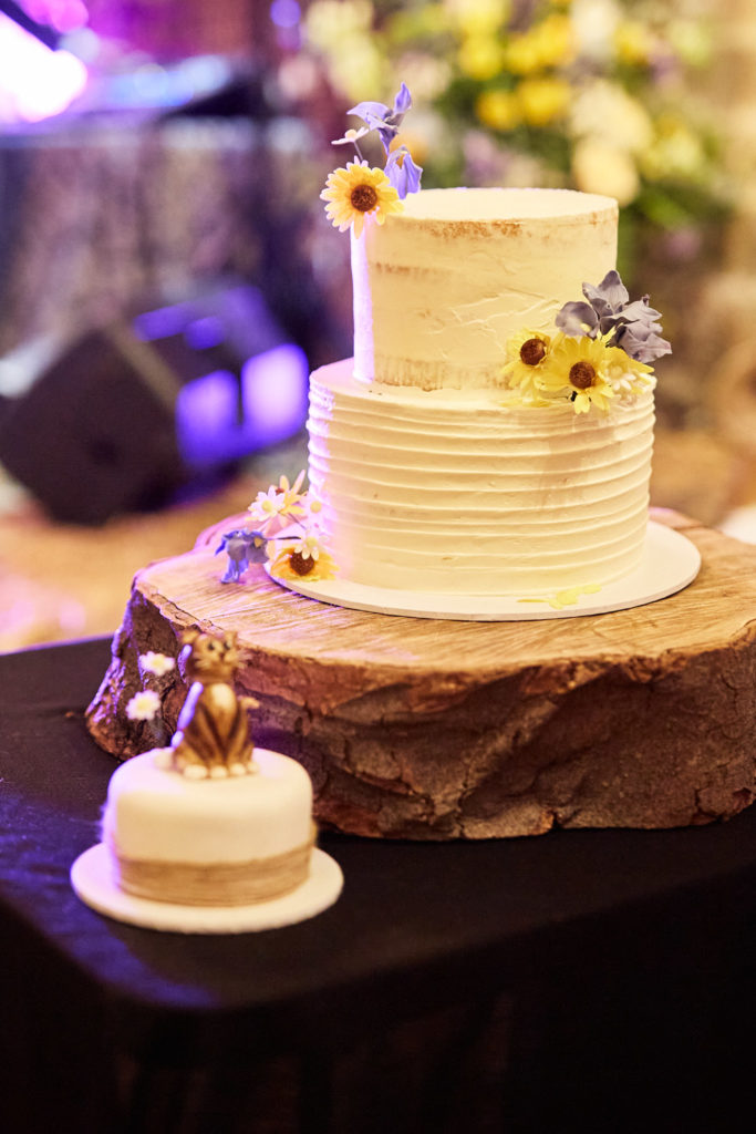 Wedding cake decorated with sunflowers on a log slice