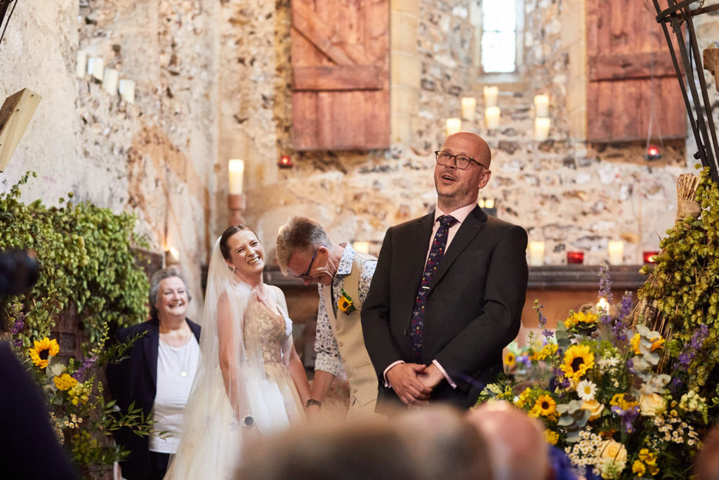 Bride and groom with the registrar during their ceremony in the church at Dode