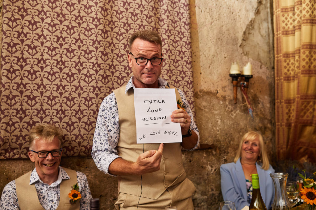 Groom holding up a sign during his speech