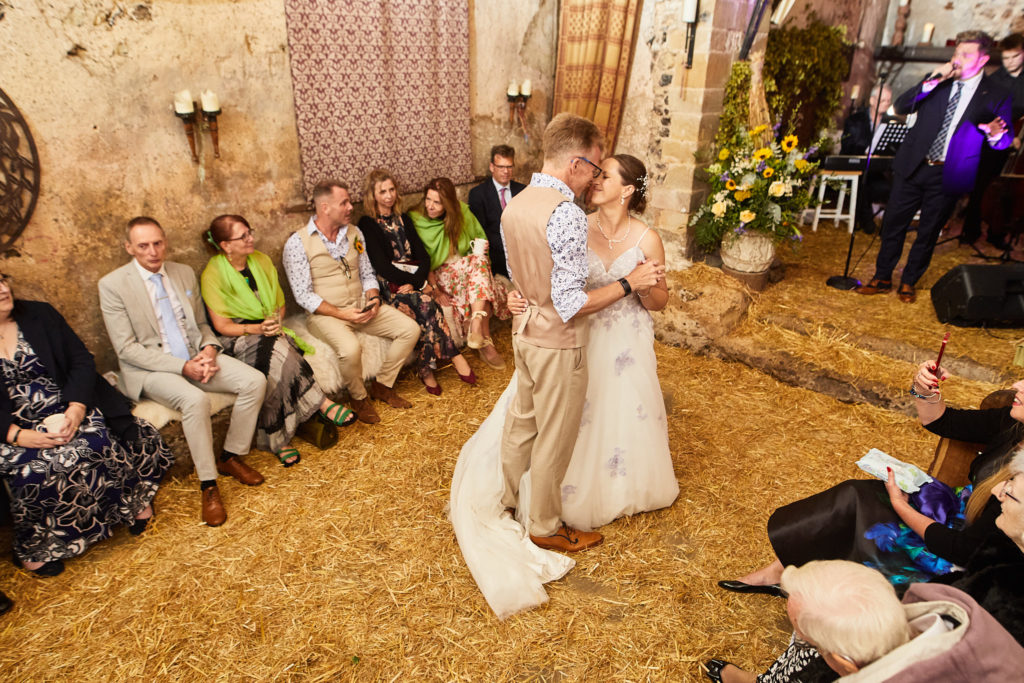 Bride and groom's first dance on the straw-covered floor of the church at Dode