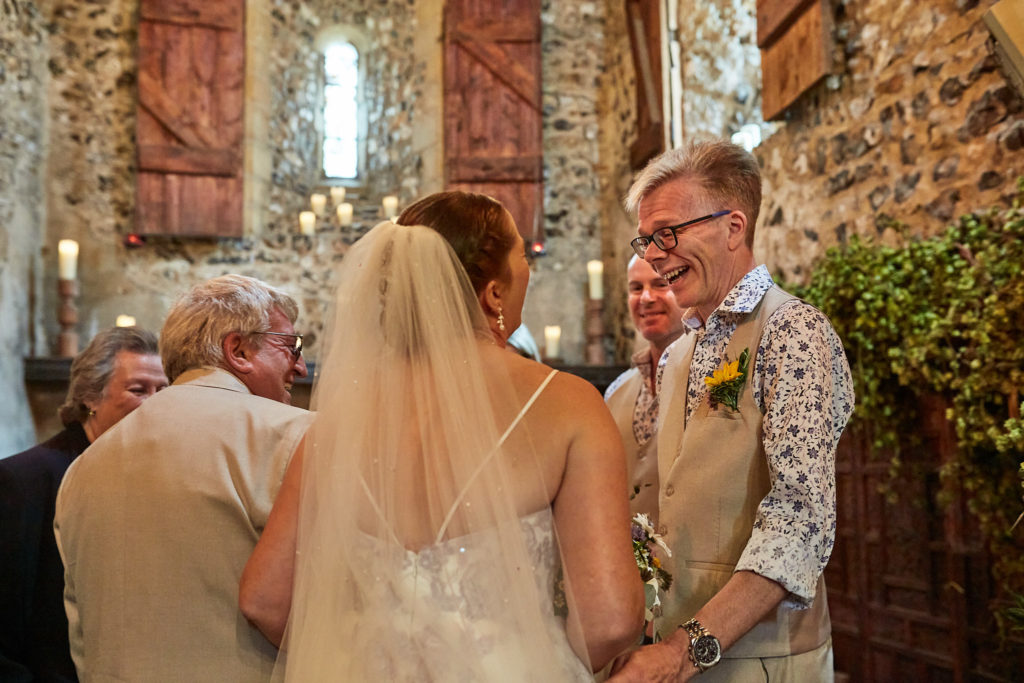 Groom smiling as the bride joins him at the front of the church