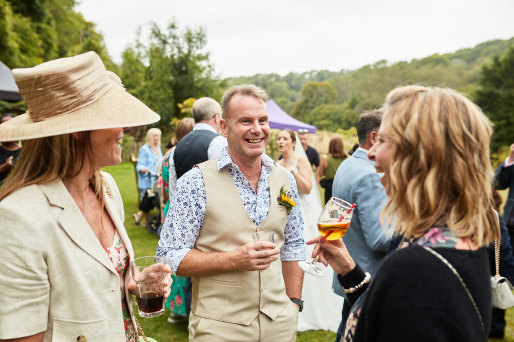 Wedding guests chatting with drinks outdoors