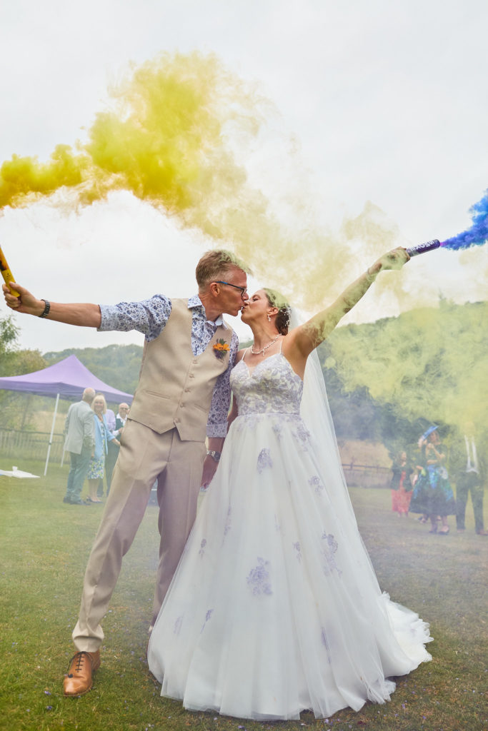 Bride and groom waving yellow and blue smoke flares at the Lost Village of Dode