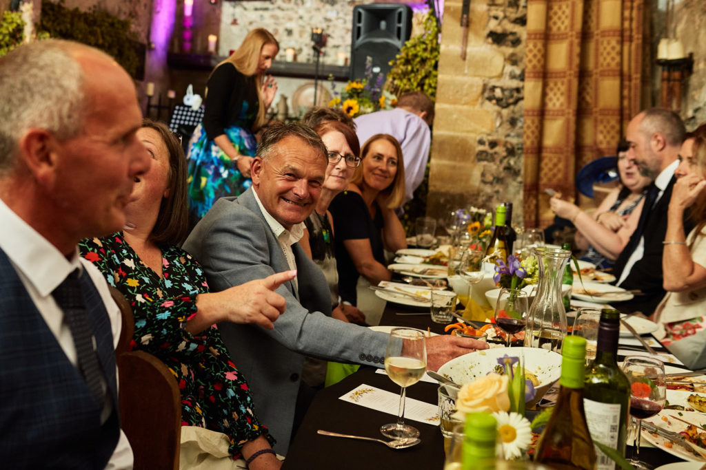 Wedding guests laughing and pointing at the table