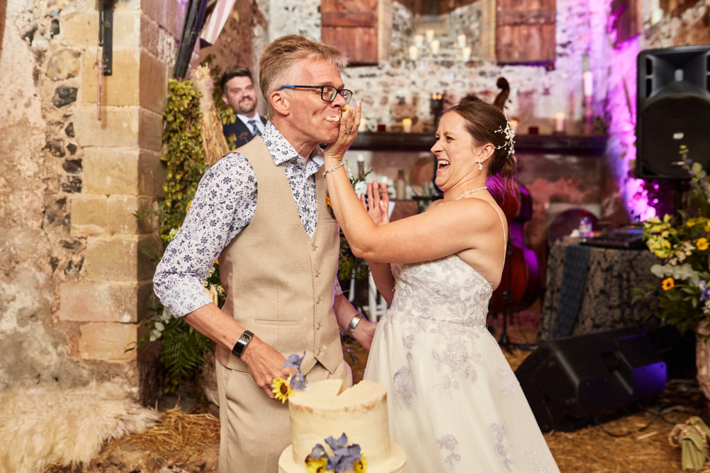 Bride feeding the groom wedding cake
