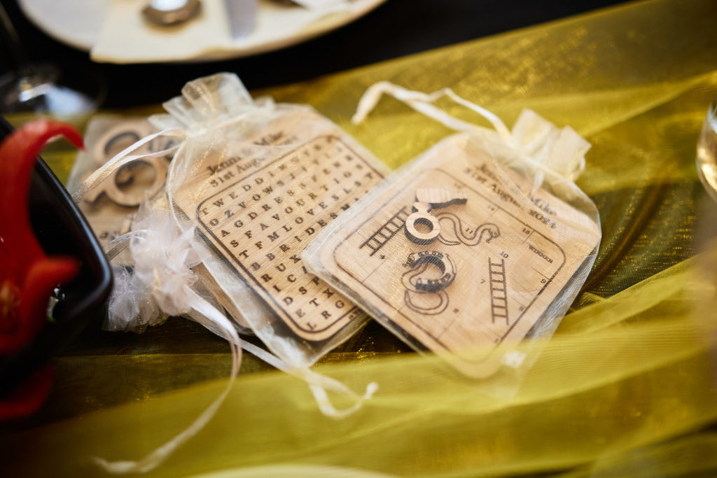 Wedding favours in organza bags on a yellow table runner