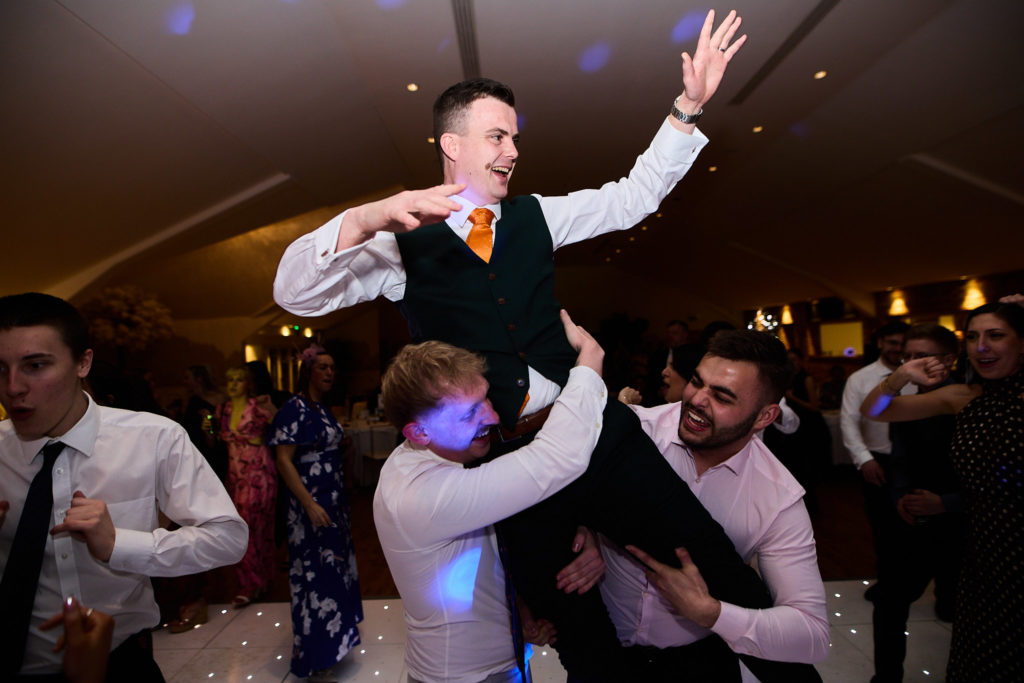 Groom lifted onto his friends' shoulders on the dance floor