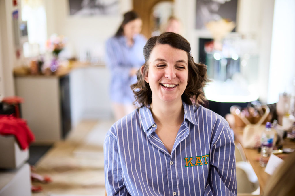 Woman in a striped pyjama shirt laughing during the morning preparations