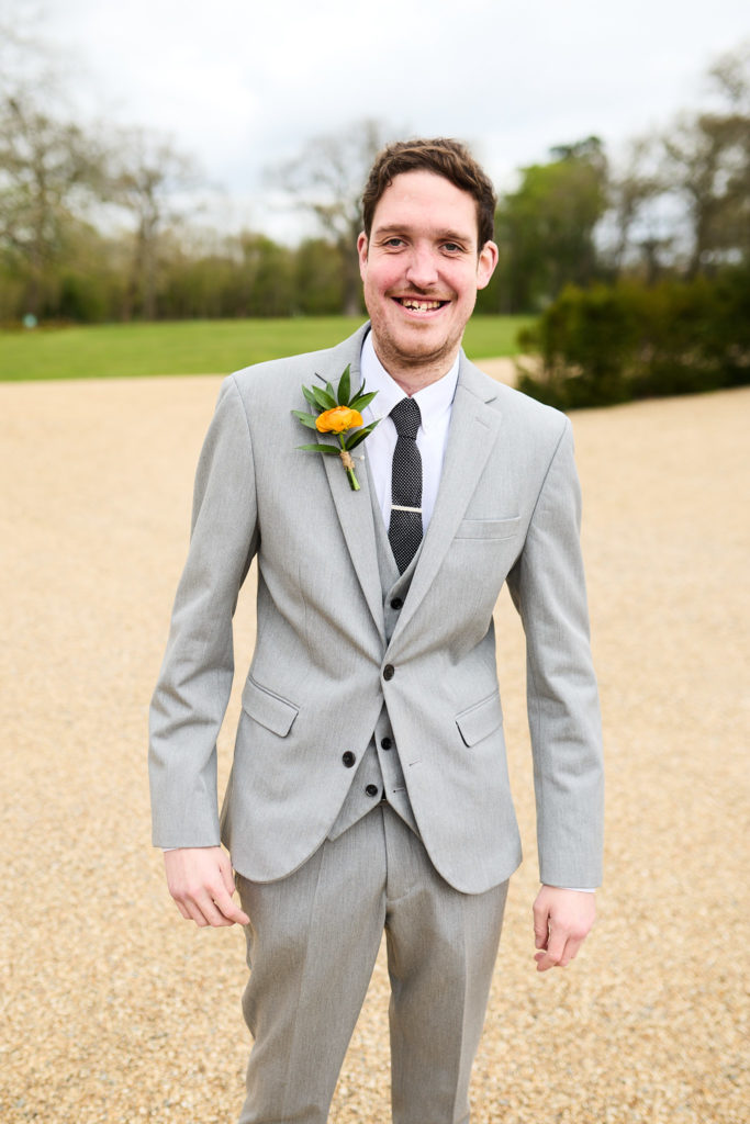 Groomsman smiling in a light grey suit