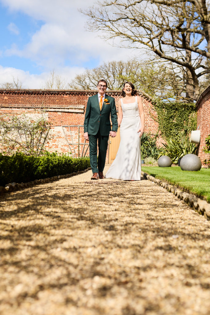 Bride and groom walking through the walled garden at Hatfield Place
