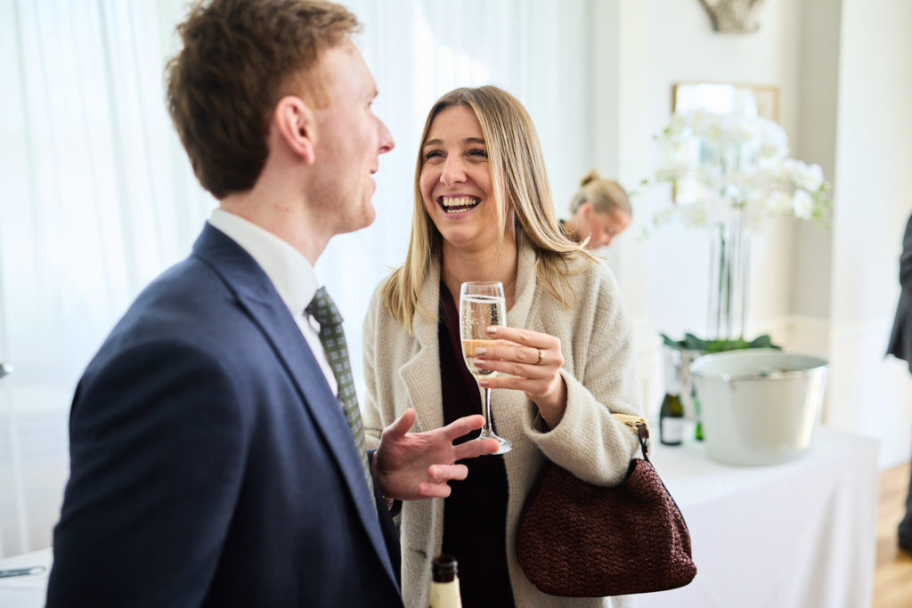 Wedding guests laughing together with drinks