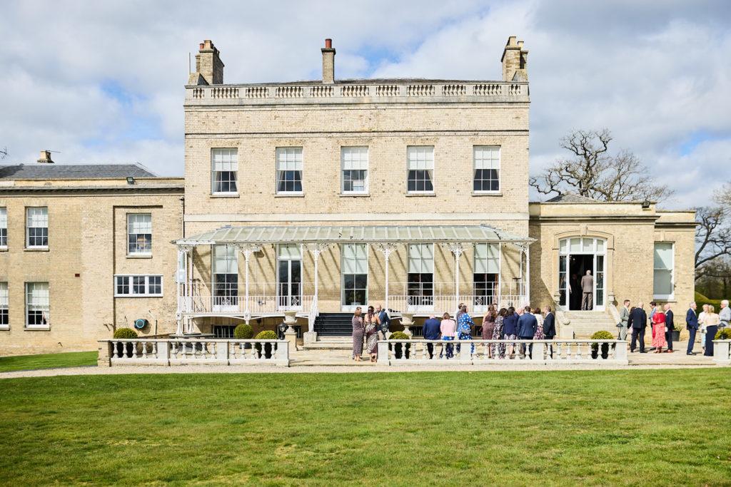 Wedding guests on the terrace in front of Hatfield Place, Essex