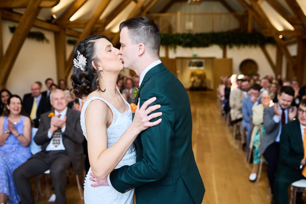 Bride and groom's first kiss as guests applaud